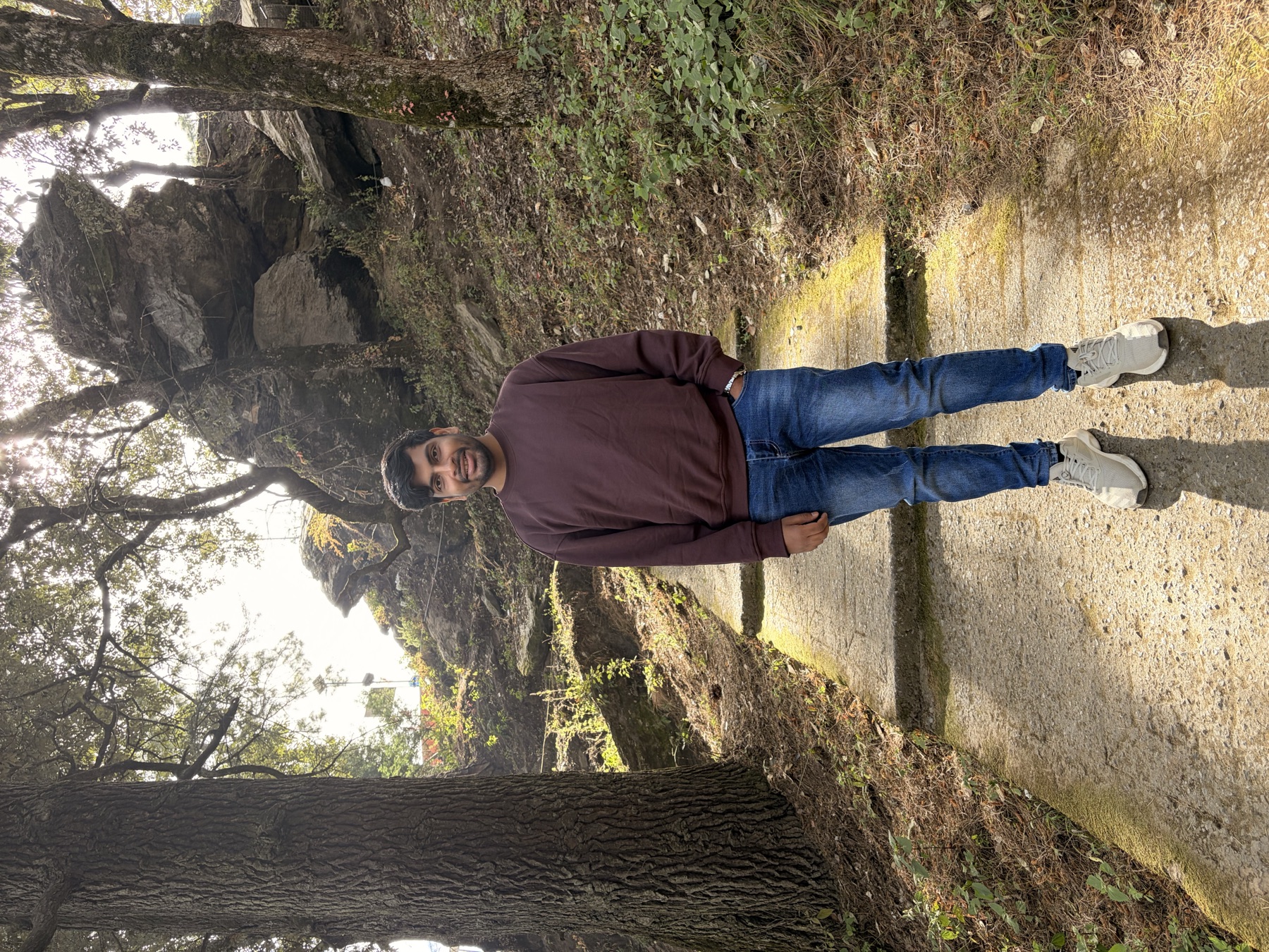 Ankit on a quiet path through a mountain forest
