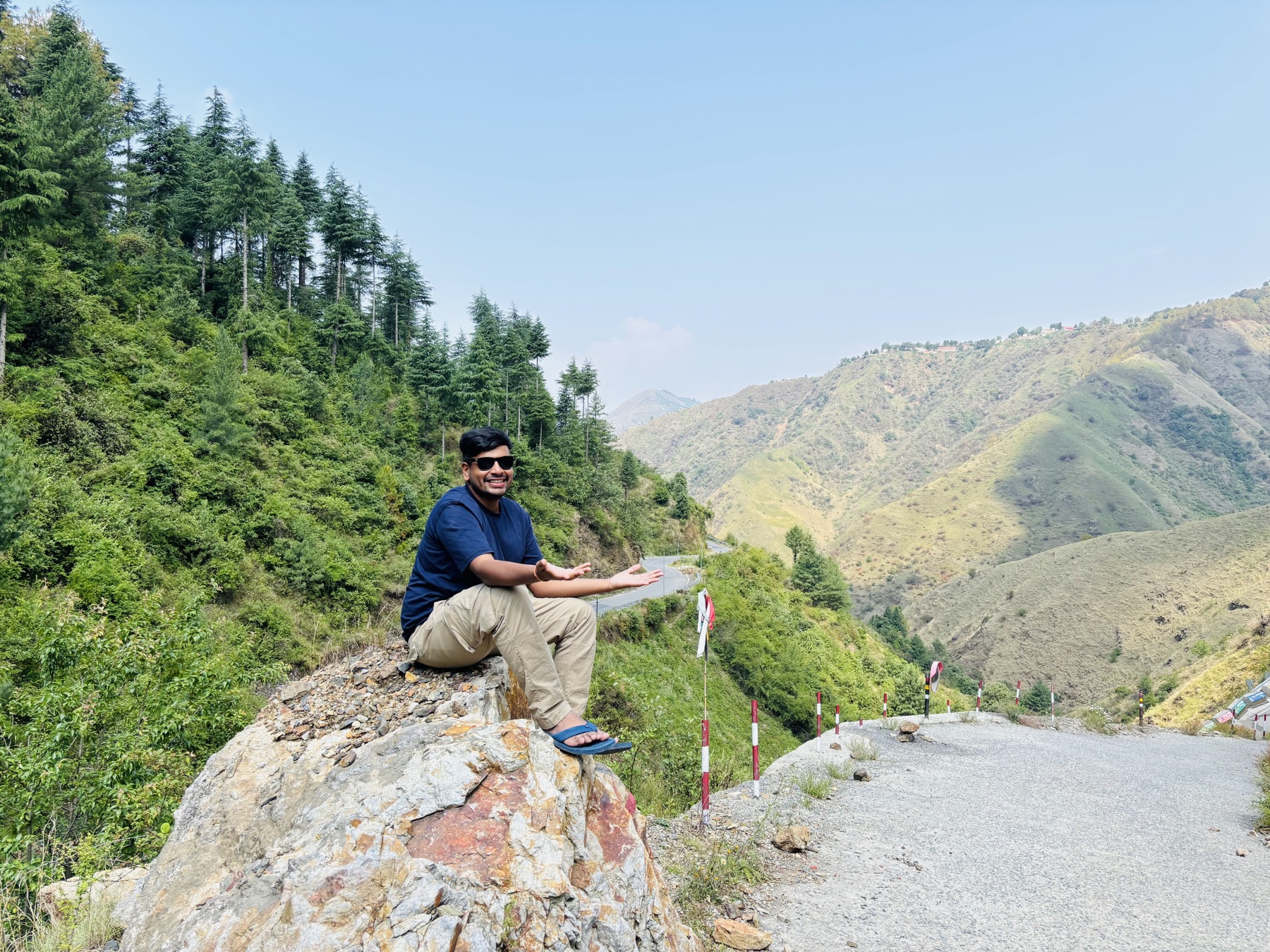 Ankit sitting beside a winding mountain road
